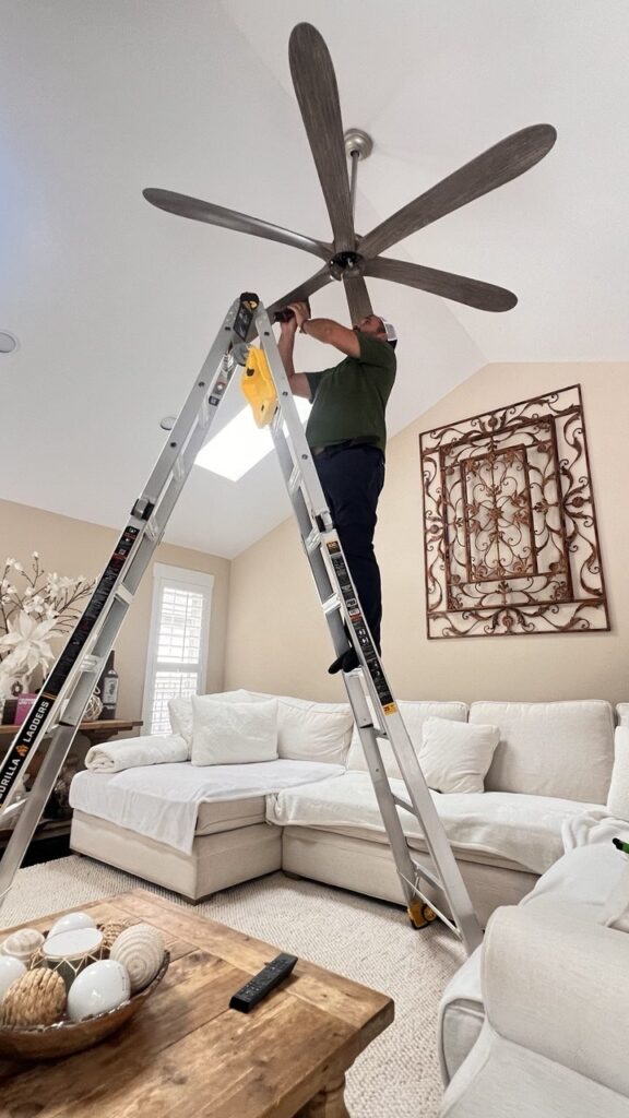 Ceiling fan installation Chicago — mounting a ceiling fan on a vaulted living-room ceiling