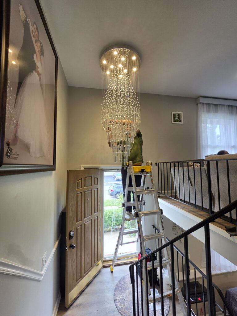 Crystal chandelier installation Chicago — finished lit chandelier in an entryway