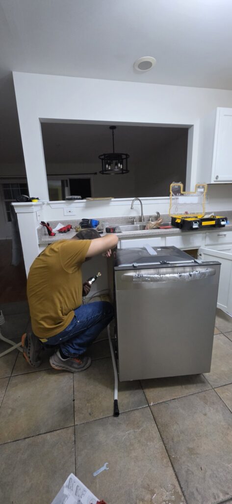 Dishwasher installation Chicago — handyman installing a new stainless dishwasher