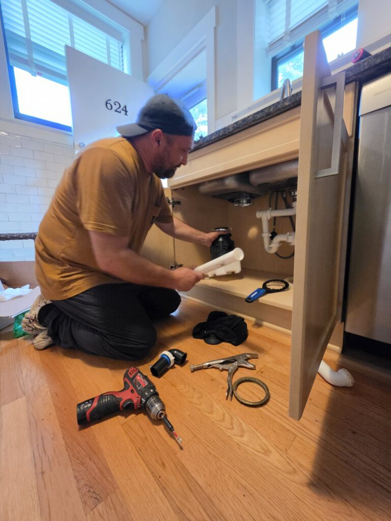 Garbage disposal installation Chicago — handyman installing a new disposal under a kitchen sink