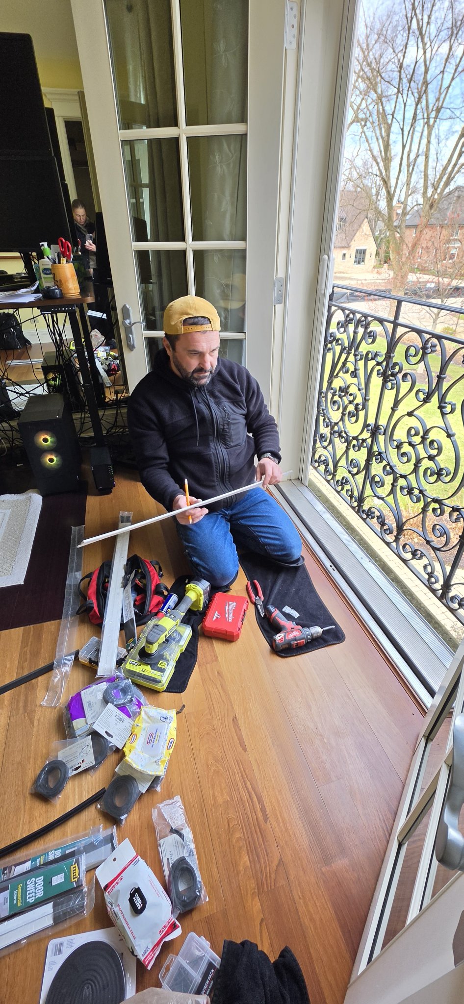 Worker weatherstripping French doors